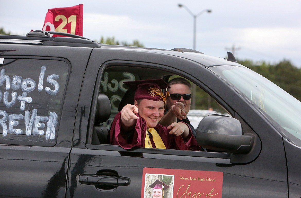 2021 Moses Lake High School graduate Blake Bilderback “cheeses” for the photo as he heads out of the Grant County Fairgrounds parking lot on Friday afternoon for the high school graduation parade.