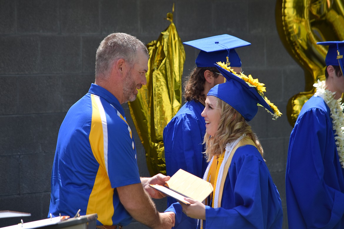 Wilson Creek High School senior Anissa Odorizzi receives her diploma from school board member Daryl Kimble during the school’s graduation ceremony on Saturday, June 12.
