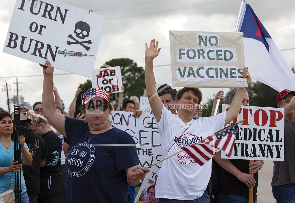 In this June 7, 2021, file photo, demonstrators at Houston Methodist Baytown Hospital in Baytown, Texas, wave at cars that honk at them to support their protest against a policy that says hospital employees must get vaccinated against COVID-19 or lose their jobs. A federal judge dismissed their lawsuit, saying if workers don’t like the rule, they can go find another job. (Yi-Chin Lee/Houston Chronicle via AP)