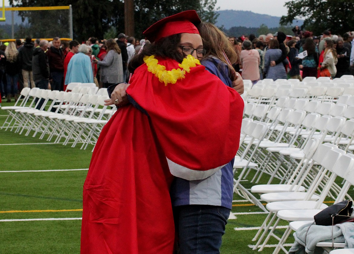 A student comes in for a hug, teary-eyed and smiling, following Sandpoint High School's graduation ceremony Friday night at War Memorial Field.