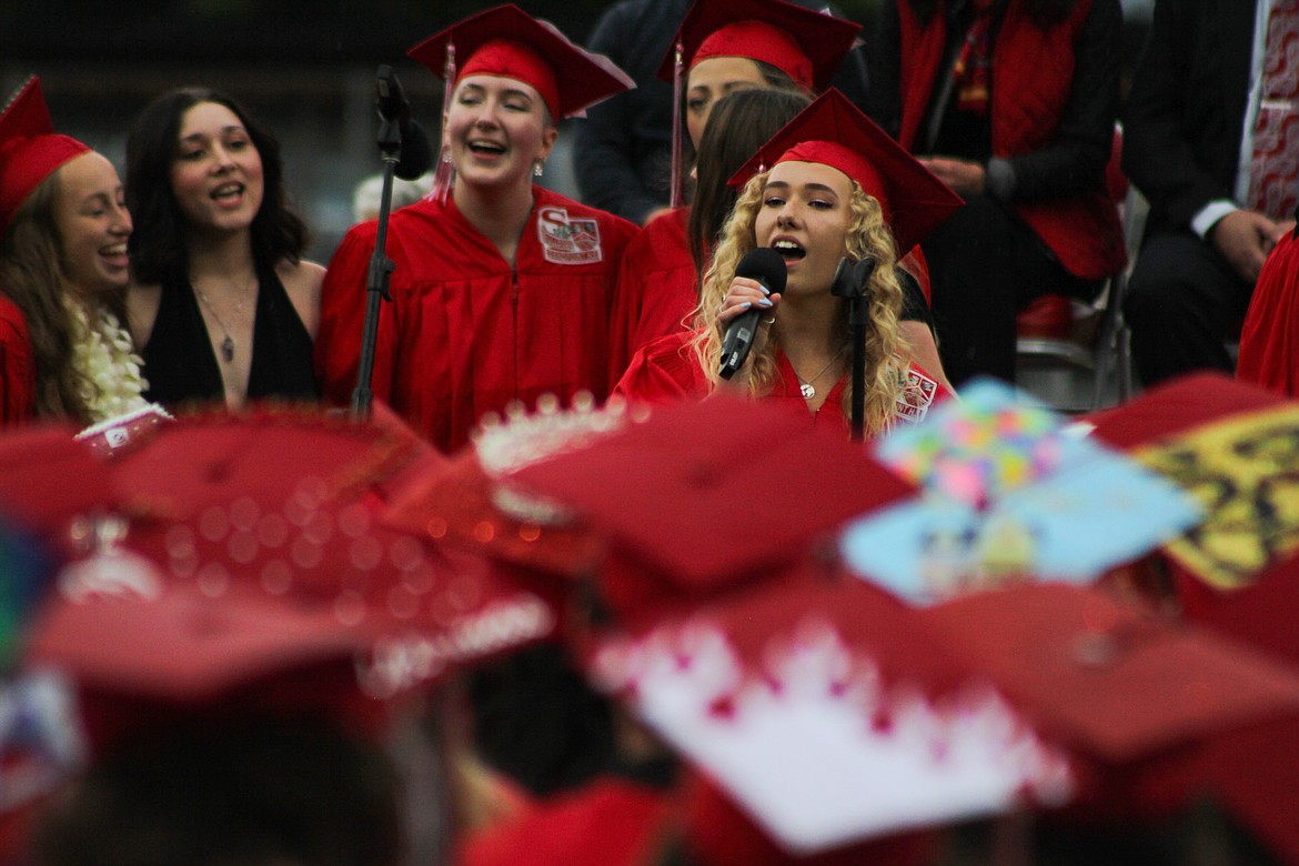 graduates and other choir members perform  “I’ll Always Remember You” Friday at War Memorial Field.