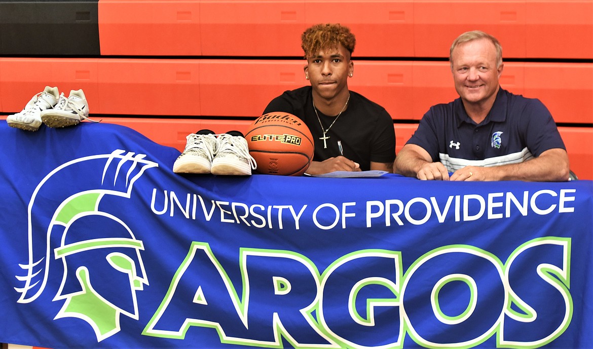 Girma Detwiler of Ronan signed a letter of intent to compete in track and basketball for the University of Providence in Great Falls. At right is Providence track and field coach Tony Arntson. (Scot Heisel/Lake County Leader)