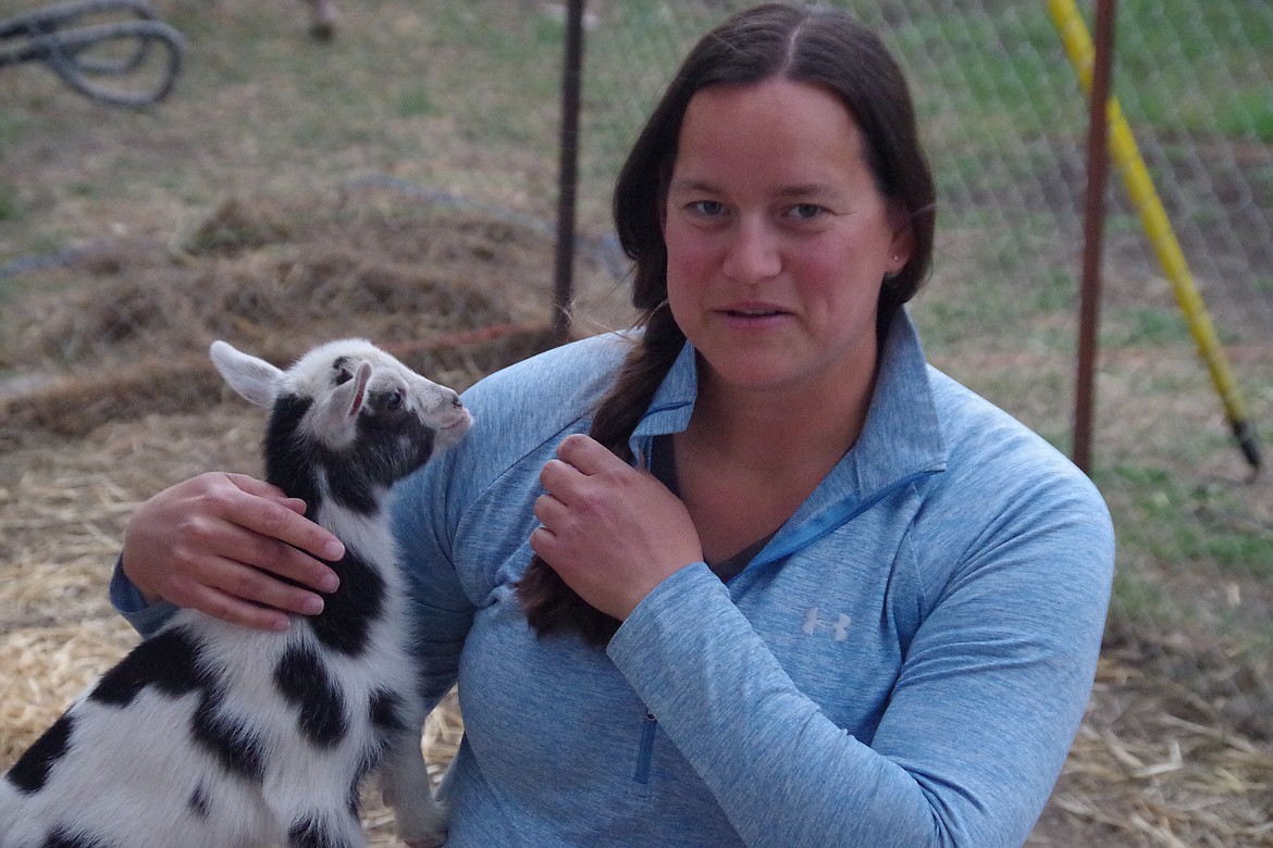 Tiffany Quilter pets one of the goats that help her during her goat yoga sessions.