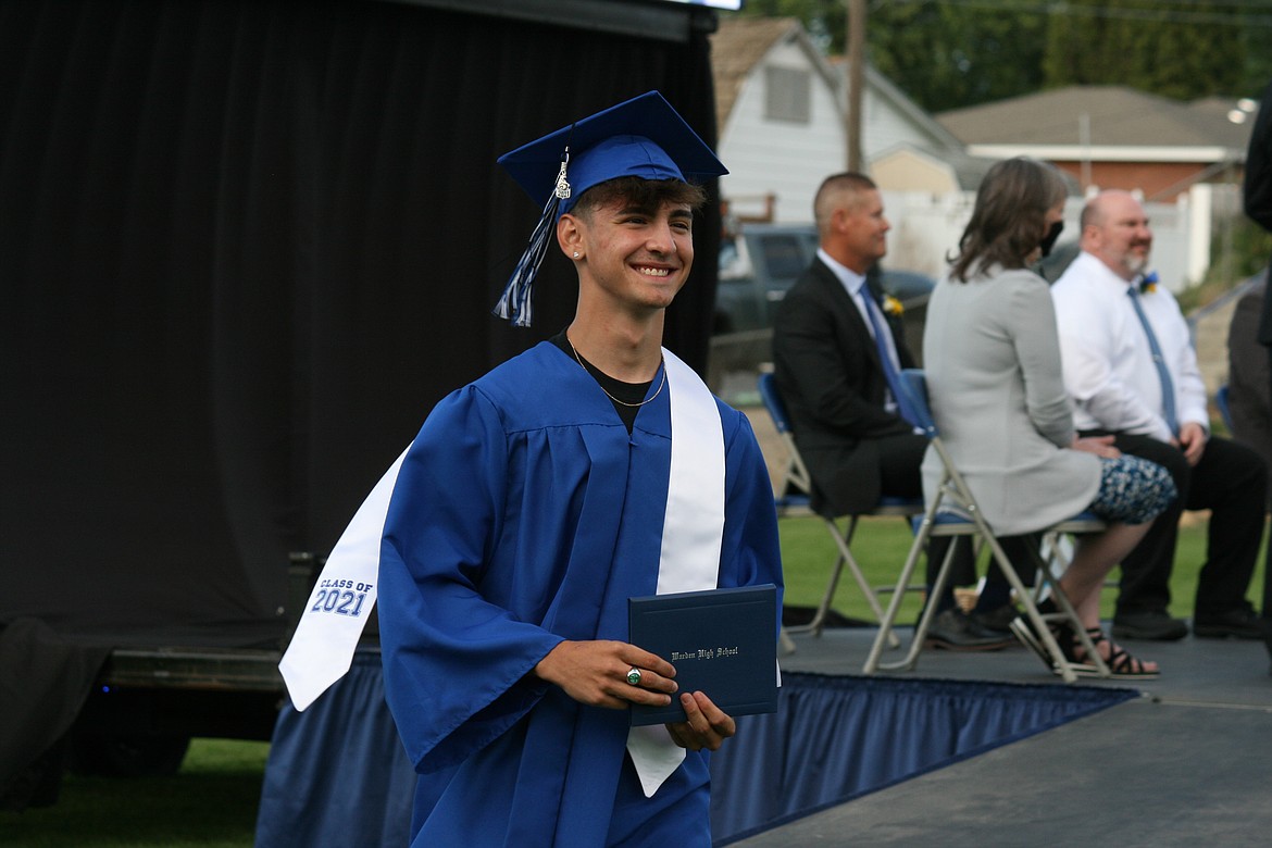 Diploma in hand, a Warden High School senior walks back to his seat during graduation ceremonies June 11.