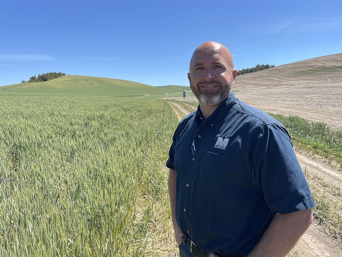 Ryan Tippett, the director of product innovation for McGregor Company, in front of a test plot on the company's 350-acre test farm near Colfax.