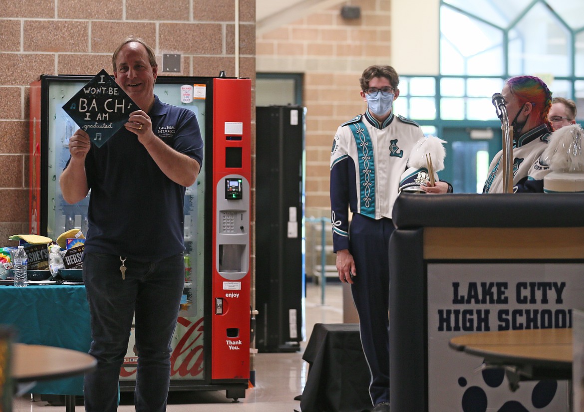 Tim Sandford smiles as he receives a mortarboard from his students that reads, "I won't be Bach, I am graduated" during a Tuesday morning celebration at Lake City High School.