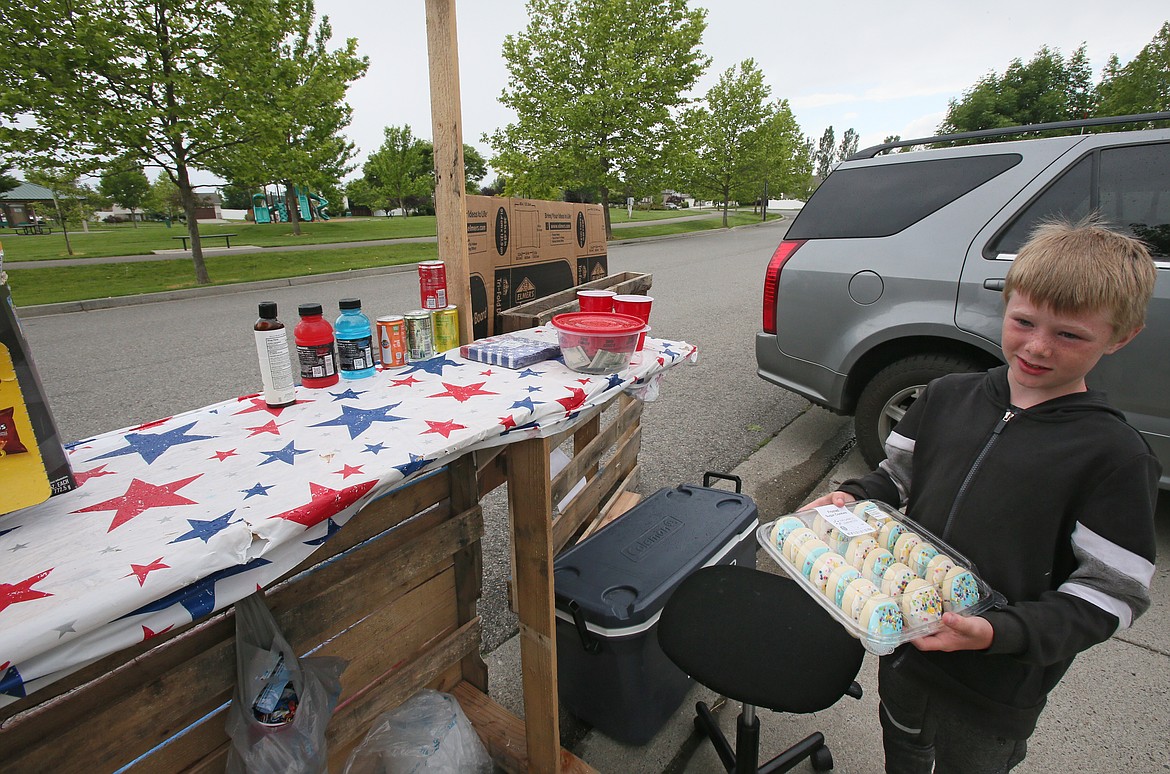 Businessman Kertin Saunders, 9, showcases a favorite sweet item in his Snack Shack inventory on Tuesday. Kertin's stand will be open three days a week this summer as he also raises money for the Kootenai Humane Society.