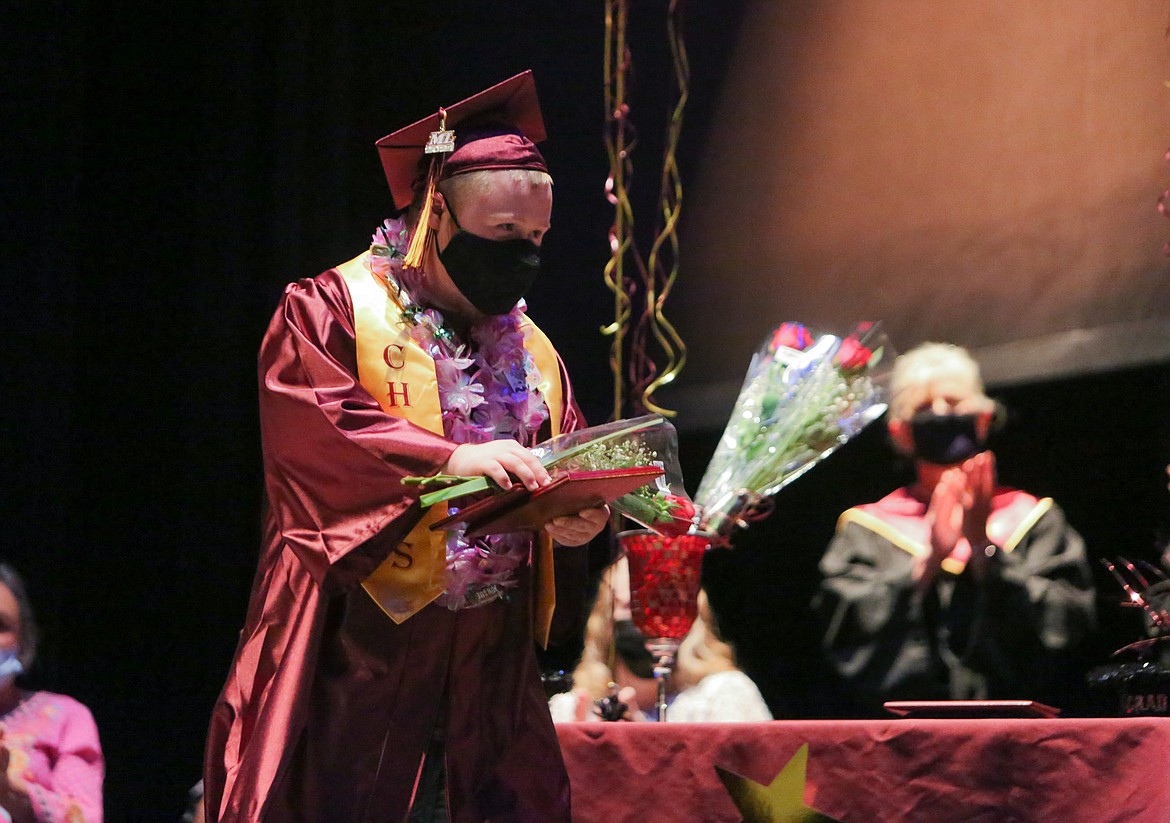 Moses Lake High School 2021 graduate Brogin Mathenia walks across the theater stage after receiving a rose and his diploma on Wednesday afternoon.