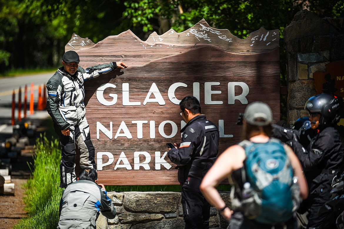 Visitors take pictures at the Glacier National Park sign in West Glacier in this June 17, 2021, file photo. (Casey Kreider/Daily Inter Lake)