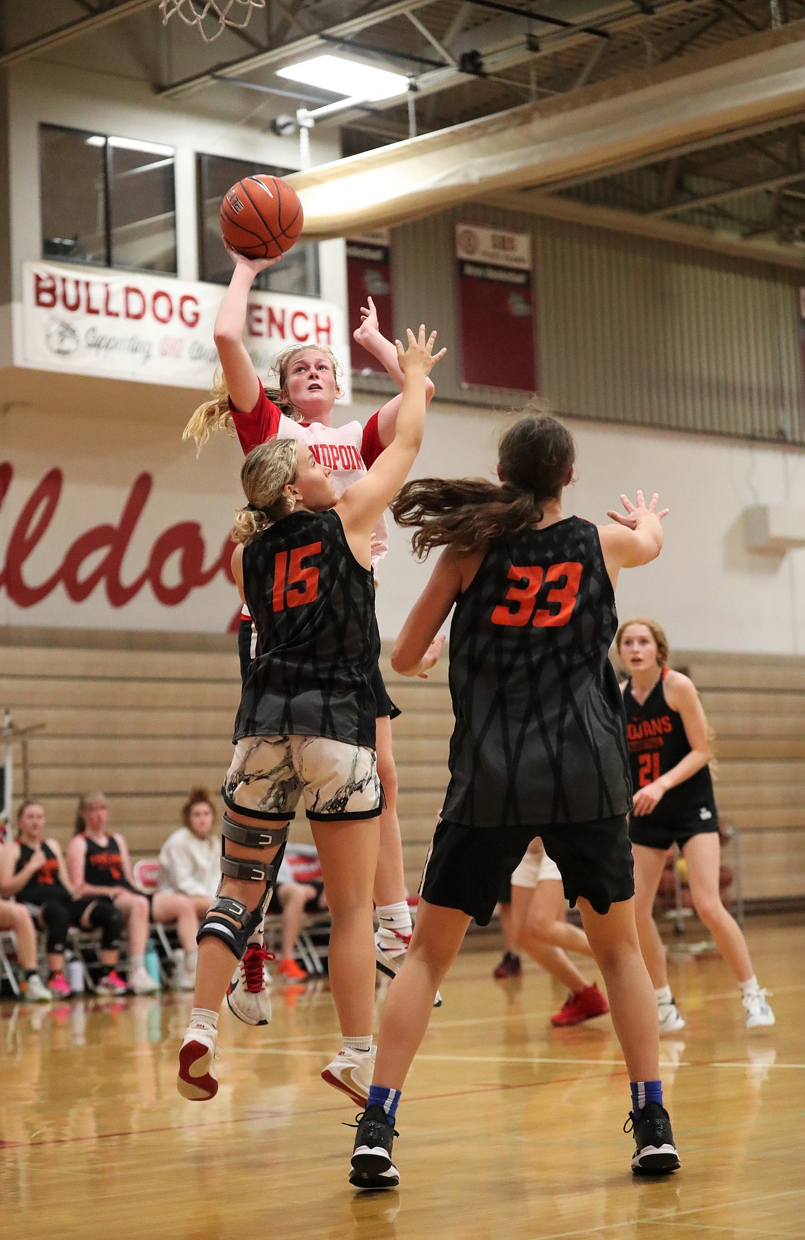 Sofia Platte rises up for a shot over a pair of Post Falls defenders on Tuesday.