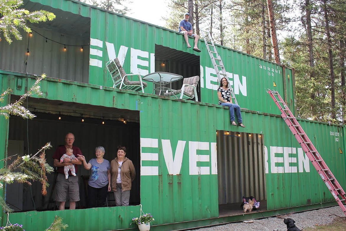 The Bigart family shows off their storage container house. On the top level is John Bigart III and on the second level is Elena Bigart. On the bottom level are grandmothers Jacquie Bigart and Evgeniya Nikolaeva, who was visiting from Moscow, Russia, and Grampa John Bigart II holding Bella. Bob, the black lab, was also part of the festivities. (Monte Turner/Mineral Independent)