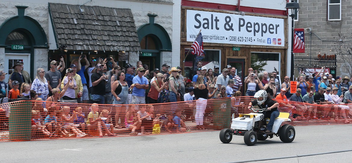 Kirsten Thomson of Post Falls zooms along Maine Street as the crowd goes wild during the Big Back-In lawnmower races in Spirit Lake on Sunday.