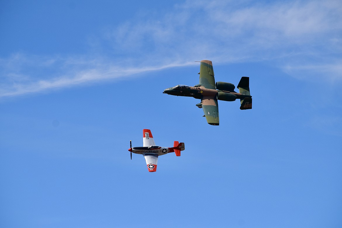 A U.S. Air Force A-10 jet with a Vietnam-era paint job and a World War II-era P-51 Mustang fly in formation as part of an Air Force heritage flight celebrating the service’s history during the 2021 Moses Lake Airshow.