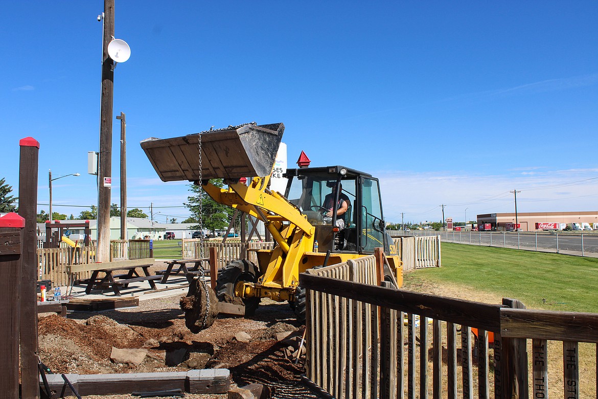 Moses Lake Christian Church volunteers remove a concrete block from the bark at Doolittle Dream Park.