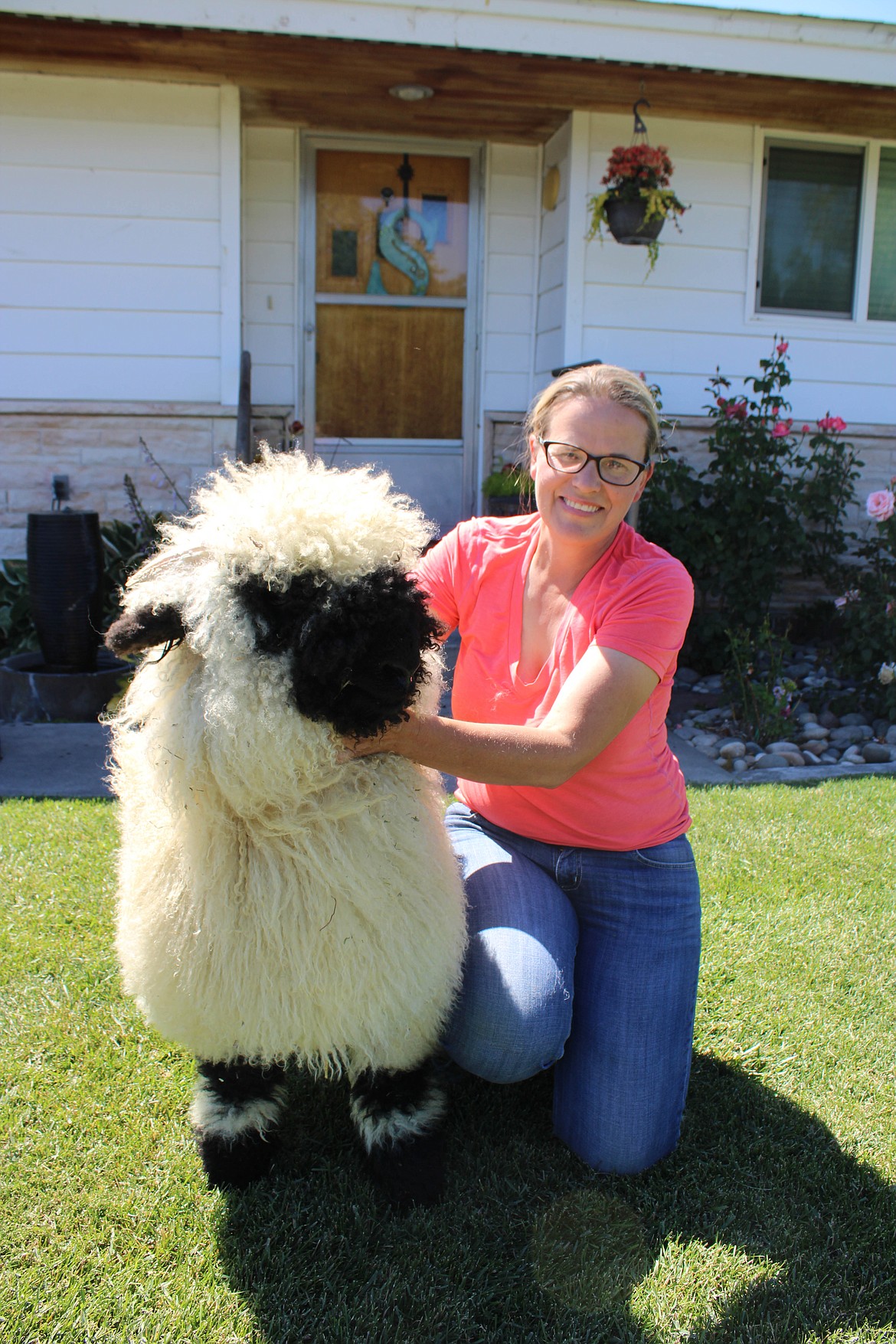 Sarah Smith smiles with Remarkable, a Valais Blacknose sheep.