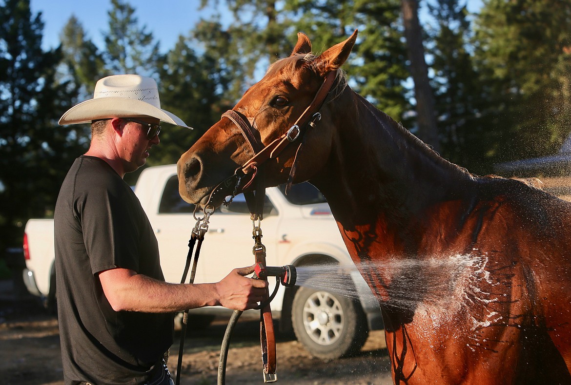 Laine Averill hoses down his horse after an evening of team roping practice. 
Mackenzie Reiss/Bigfork Eagle