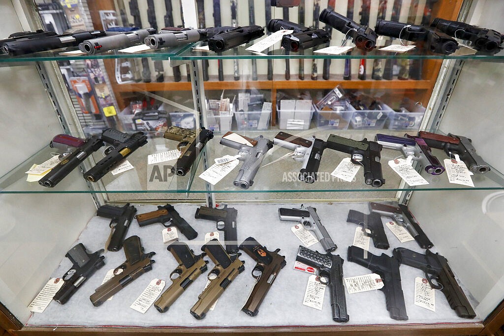 In this March 25, 2020, file photo semi-automatic handguns are displayed at shop in New Castle, Pa. The number of people stopped from buying guns though the U.S. background check system hit an all-time high of more than 300,000 last year amid a surge of firearm sales, according to new records obtained by the group Everytown for Gun Safety. The FBI numbers provided to The Associated Press show the background checks blocked nearly twice as many gun sales in 2020 as in the year before. (AP Photo/Keith Srakocic, File)