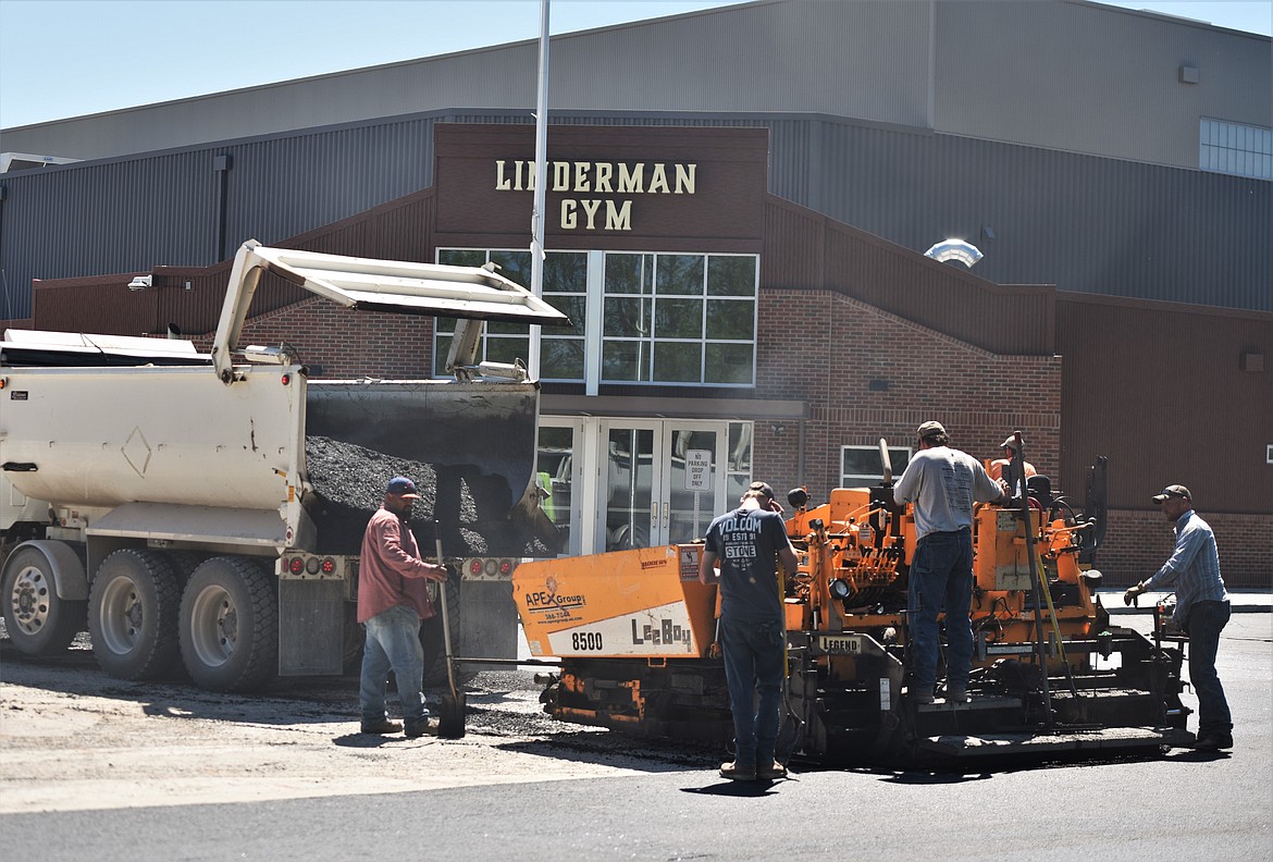 A crew paves the parking lot in front of the new Linderman Gymnasium last week. (Scot Heisel/Lake County Leader)