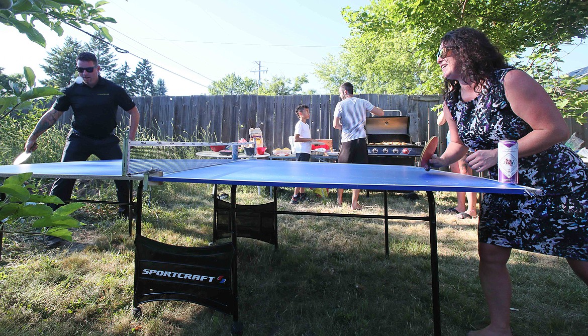 Mike Larsen and Ruth Brand, both of Coeur d'Alene, battle it out on the pingpong table during this week's Monday Night Dinner at Adam Schluter's house.