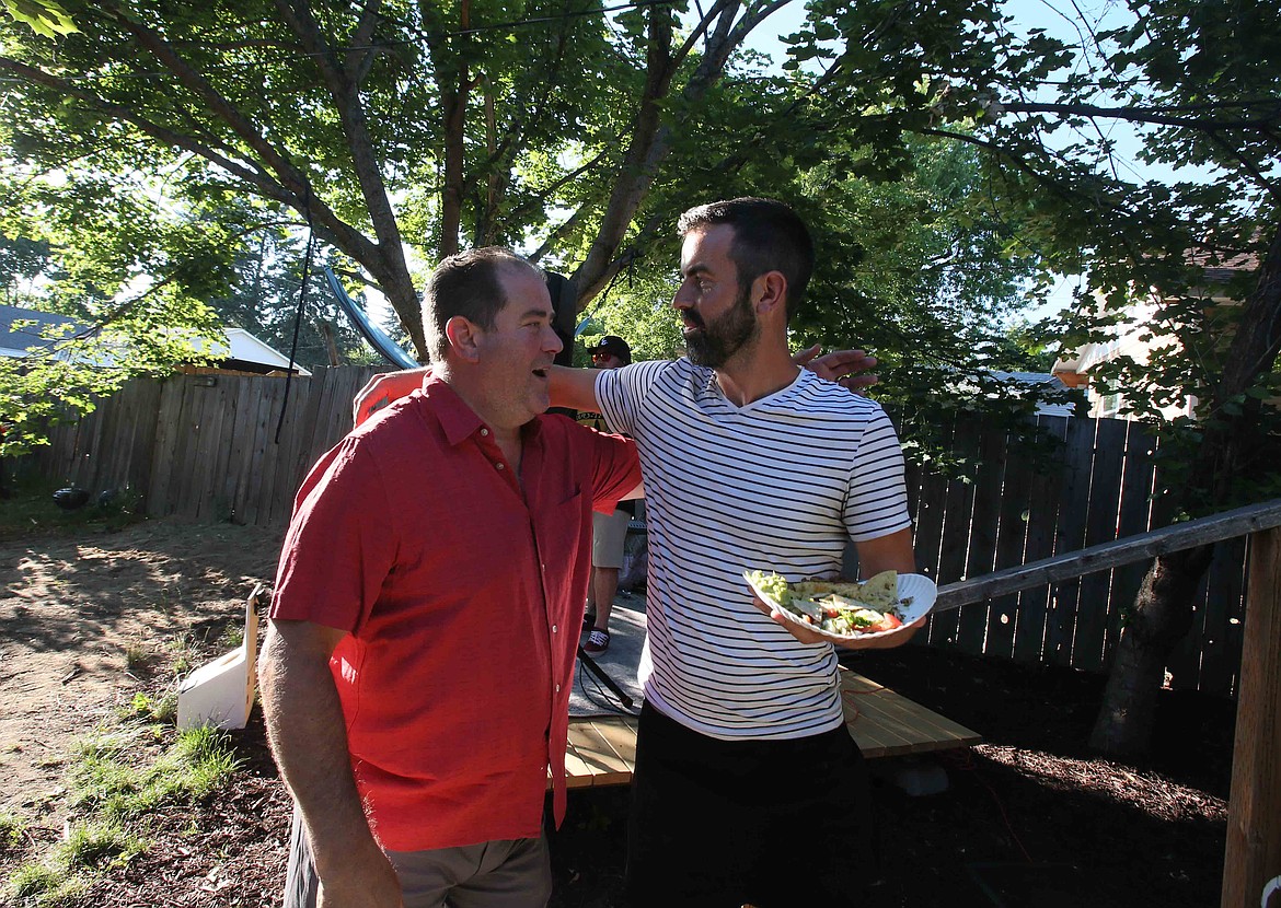 Adam Schluter, right, hugs friend Steve Patterson goodbye during this week's Monday Night Dinner at Schluter's house.