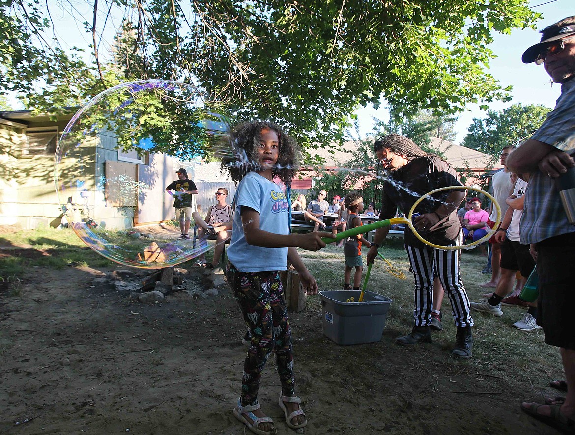 Dellami Dixon, 8, has fun with bubbles during Monday Night Dinner in Adam Schluter's back yard in Coeur d'Alene. Every other Monday, Schluter hosts community gatherings where literally everyone is welcome. "This is connection in the purest sense of the word,” he said.