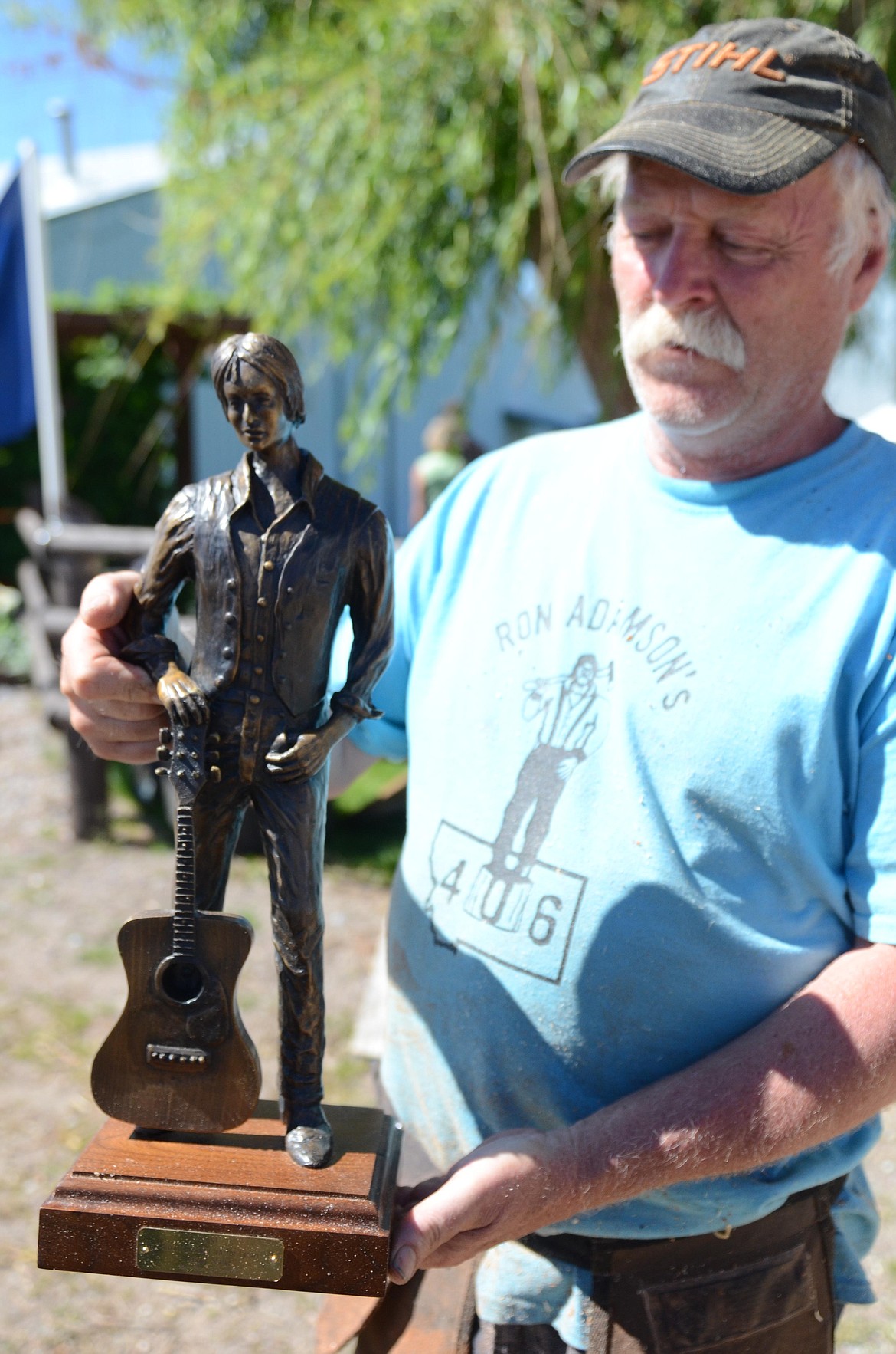 Ron Adamson of Libby, who took third in this year's Chainsaw Rendezvous, displays a small replica of his famous "Standin' on the Corner" sculpture in Winslow, Ariz. The original was created in 1999 to capture the feel of the Eagles song "Take it Easy." Millions of people veer off of I-40 onto Route 66 through Winslow to have their picture taken with the statue. Coincidentally, years after the statue was created, Adamson found a photo of his grandfather as a youth, standing on Route 66 with his guitar on his toe, almost exactly like the statue. (Carolyn Hidy/Lake County Leader)