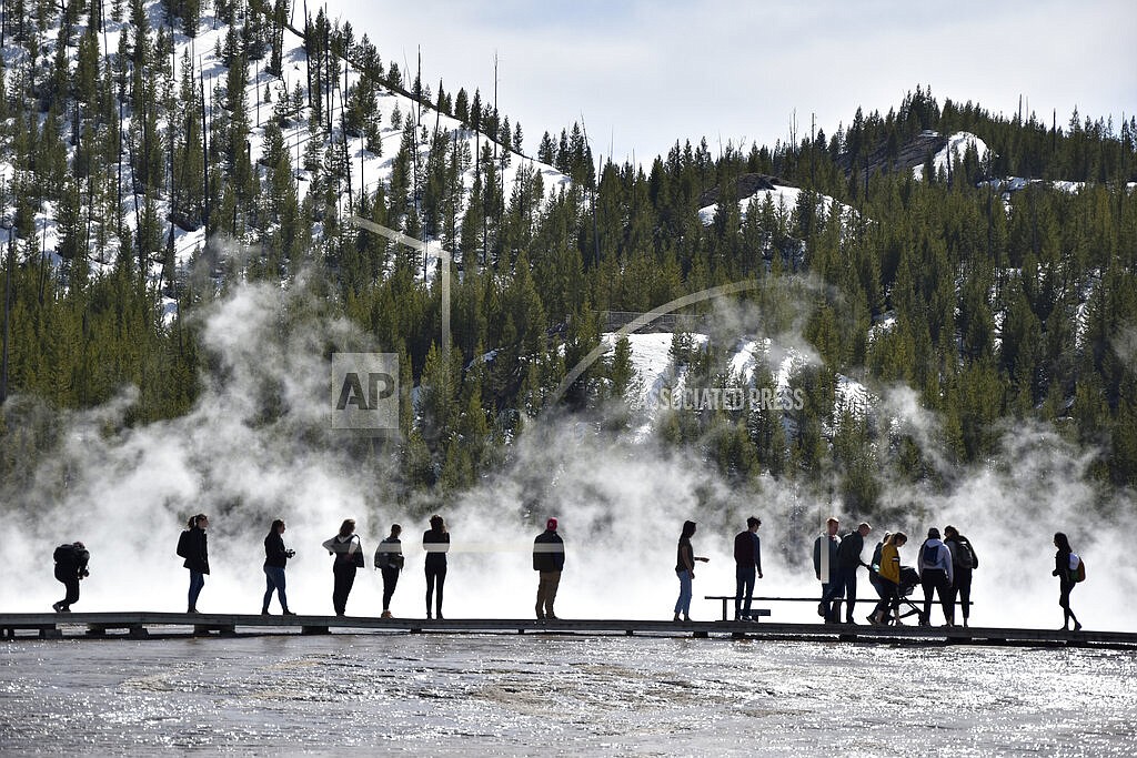 isitors are seen at Grand Prismatic Spring in Yellowstone National Park, Wyoming on May 1, 2021. A study by federal and university researchers says average park temperatures in recent decades were likely the warmest of the last 800,000 years. (AP Photo/Iris Samuels)