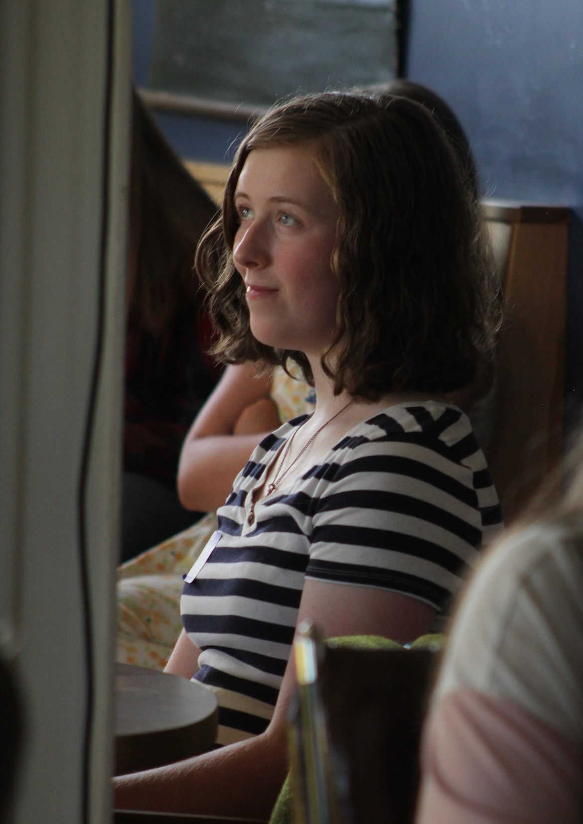 Clara Falconer, a previous year's beneficiary, listens to her mother speak Wednesday at the Longshot.