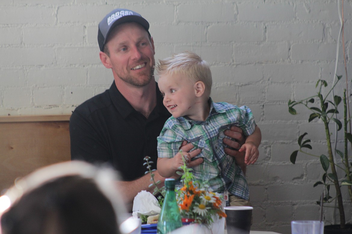 Colton Byers is held by his father during the beneficiary dinner Wednesday night at the Longshot.