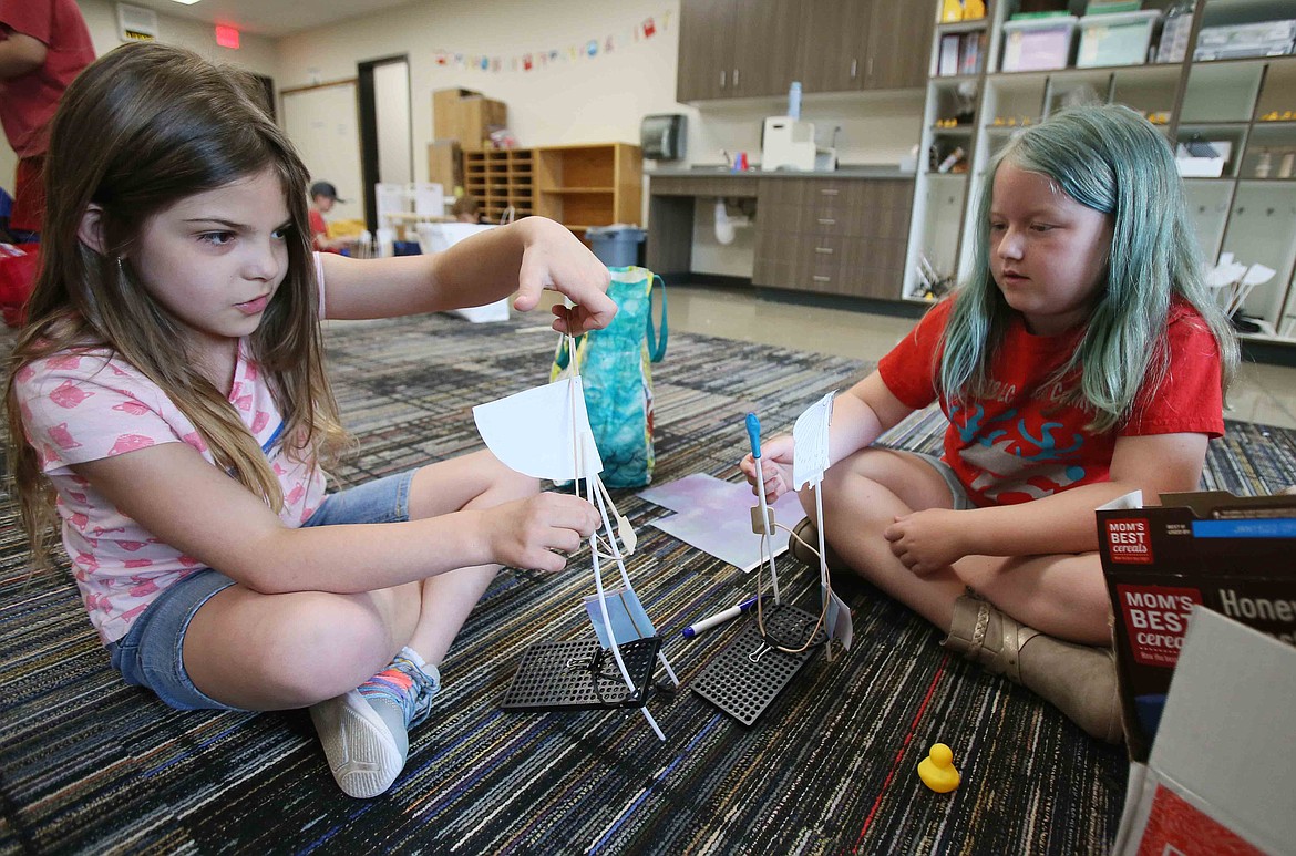 Aubriana Pacheco, 7, pulls on a rubber band as she and Adlee Krupp, 8, work on their "Duck Chuck" catapults Wednesday during Camp Invention at Northwest Expedition Academy.