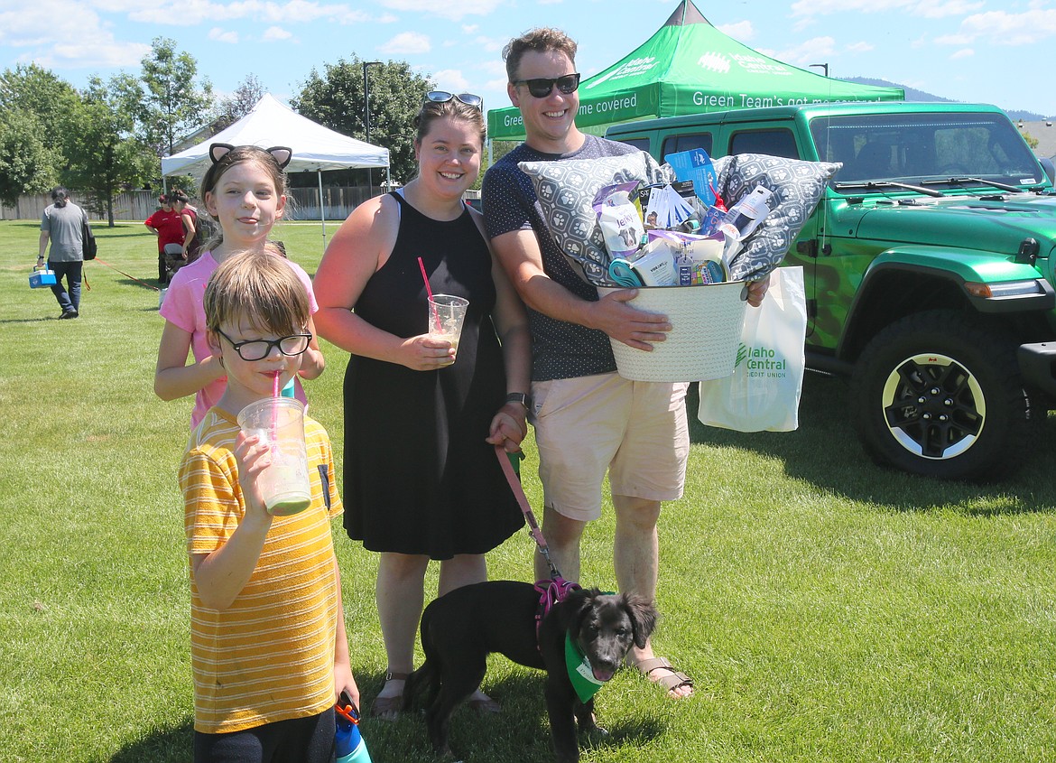 Parents Carter and Hollie Smith-Stepper, with daughter Monroe, 9, son William, 7, and 15-week-old puppy Imogen smile for the camera Saturday after winning a raffle basket filled with doggie goodies at the Dog Days of Summer-Fest in Hayden.