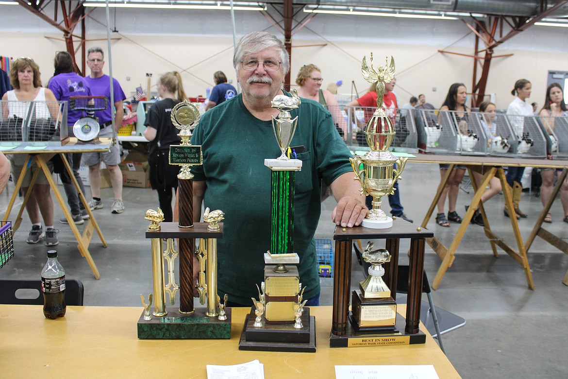 Washington State Rabbit Breeders Association President Arlin Wetzel stands with the trophies at Saturday’s convention at the Grant County Fairgrounds.