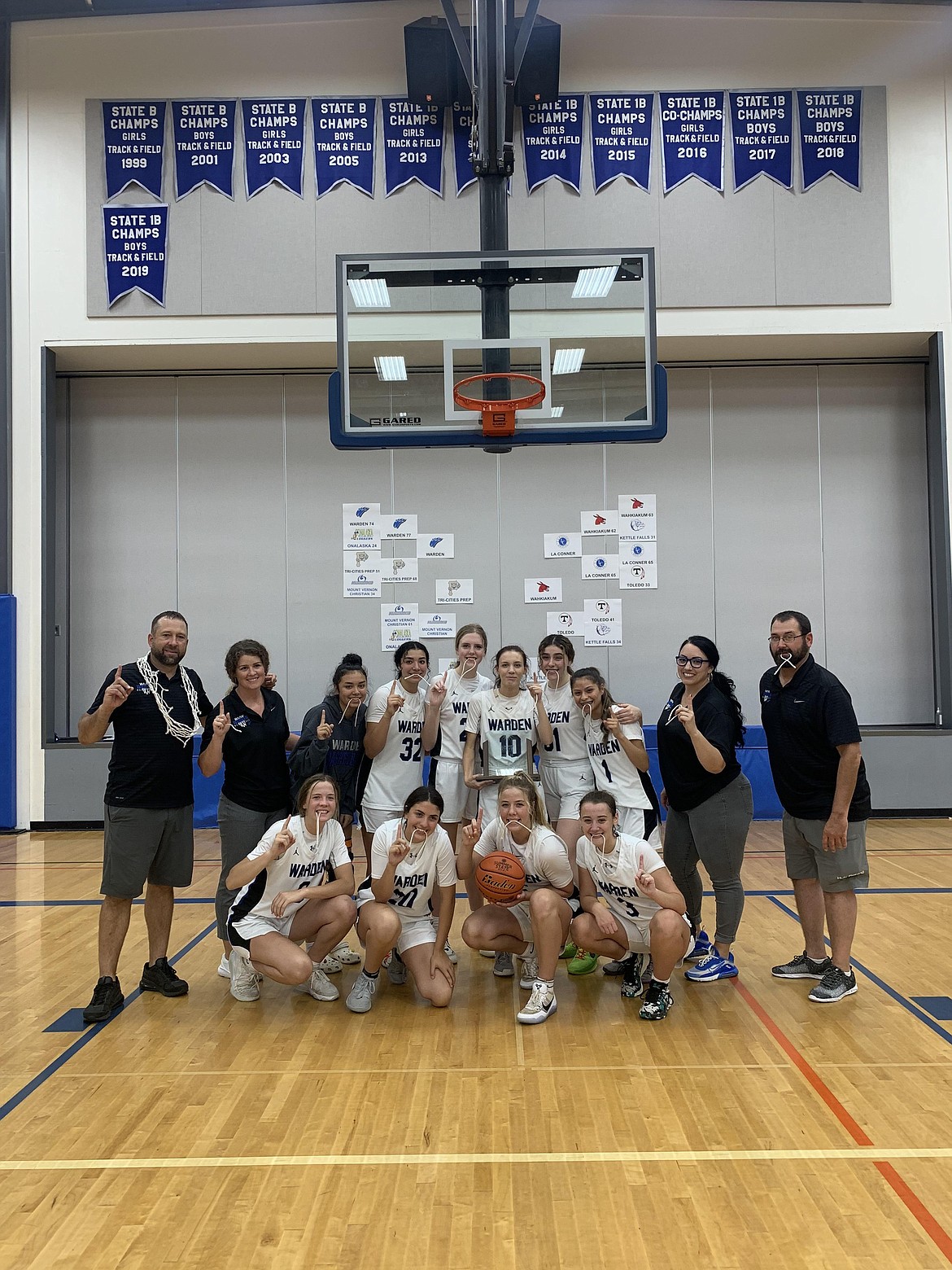 Warden High School girls basketball coaches and players pose together for a photo Friday night after winning the 2B/1B Invitational State Tournament at Mount Vernon Christian High School.