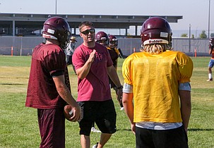 Moses Lake High School head football coach Brett Jay talks with his players in between action Tuesday morning at practice at the high school.