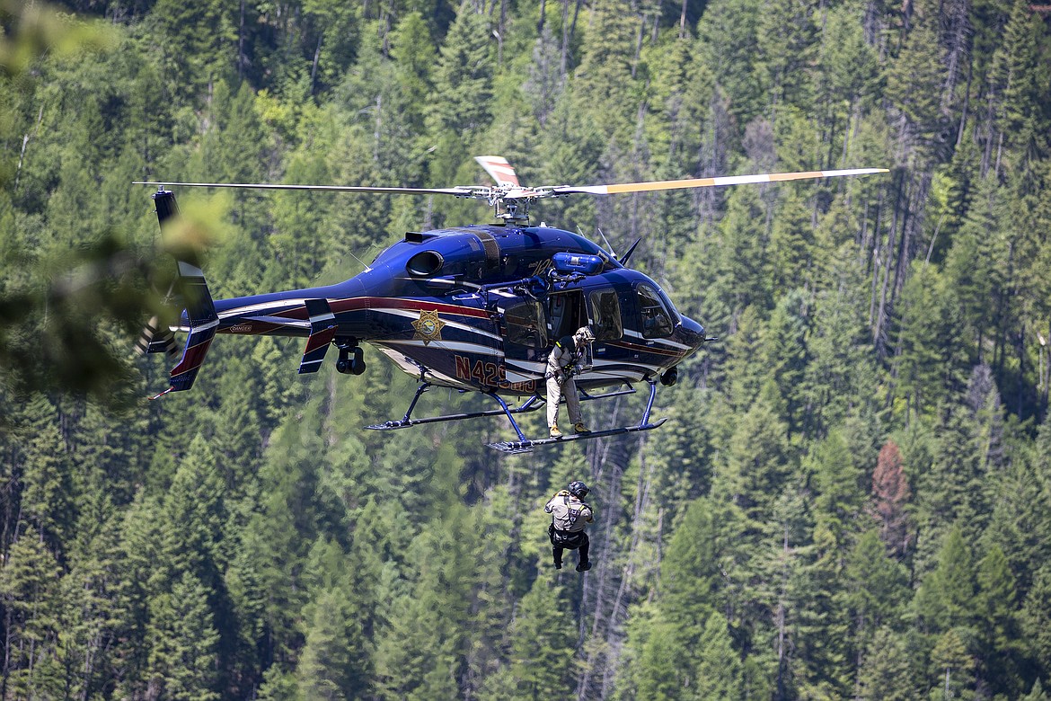 The Two Bear Air search-and-rescue helicopter lowers a crew member to the site of a wrecked vehicle below Upper Dam Road in Hungry Horse on Tuesday, June 29, 2021. A young man from the Flathead Valley died in the crash after his vehicle plummeted about 200 feet down a steep slope near the Hungry Horse Dam. (Chris Peterson/Hungry Horse News)