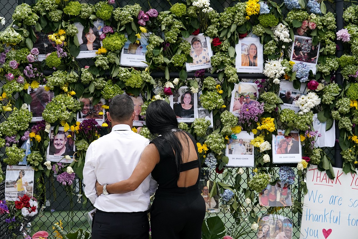 People stand near a makeshift memorial outside St. Joseph Catholic Church near the site of the collapsed Champlain Towers South condo building on Tuesday, June 29, 2021, in Surfside, Fla. Many people were still unaccounted for after Thursday's fatal collapse. (Gerald Herbert/Associated Press)