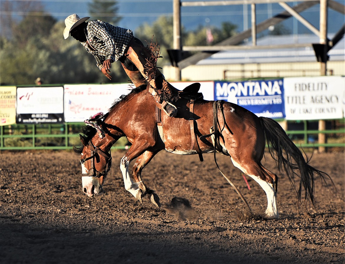 Kordell Walker of Elmo braces for a sudden dismount during the saddle bronc competition. (Scot Heisel/Lake County Leader)