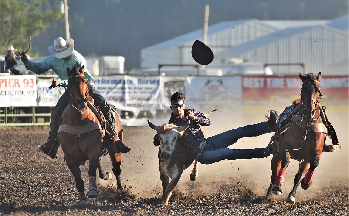 Tyler Houle of Polson grabs some horns during Saturday's steer wrestling competition. (Scot Heisel/Lake County Leader)