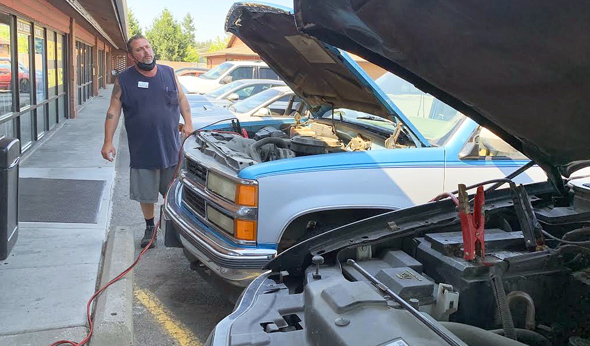 Chuck Leighton tries to start a vehicle that broke down in Tuesday's heat.