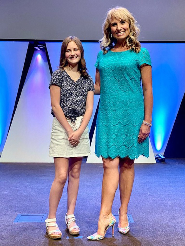 Debbie Roeber of Moses Lake stands on stage at Moses Lake Alliance Church with sixth-grader Ella Echternkamp after a voice recital on June 13.