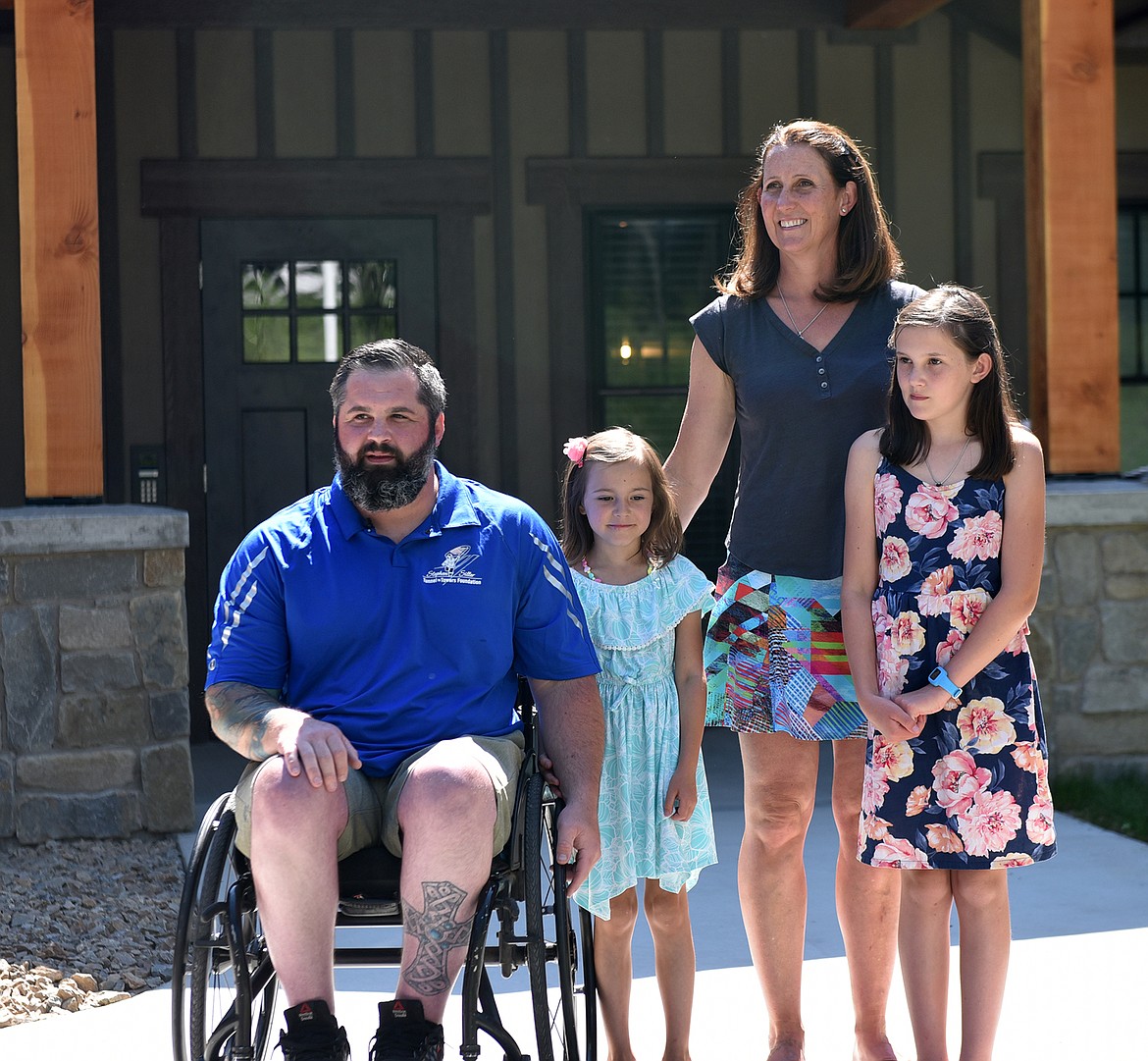 Austin Reese, his wife Charity and their daughters Aspen and Nadia, stand outside their new home Thursday morning. The home was constructed by the Tunnel to Towers Foundation, which custom builds specially adapted mortgage-free smart homes to help injured veterans and first responders. (Heidi Desch/Whitefish Pilot)