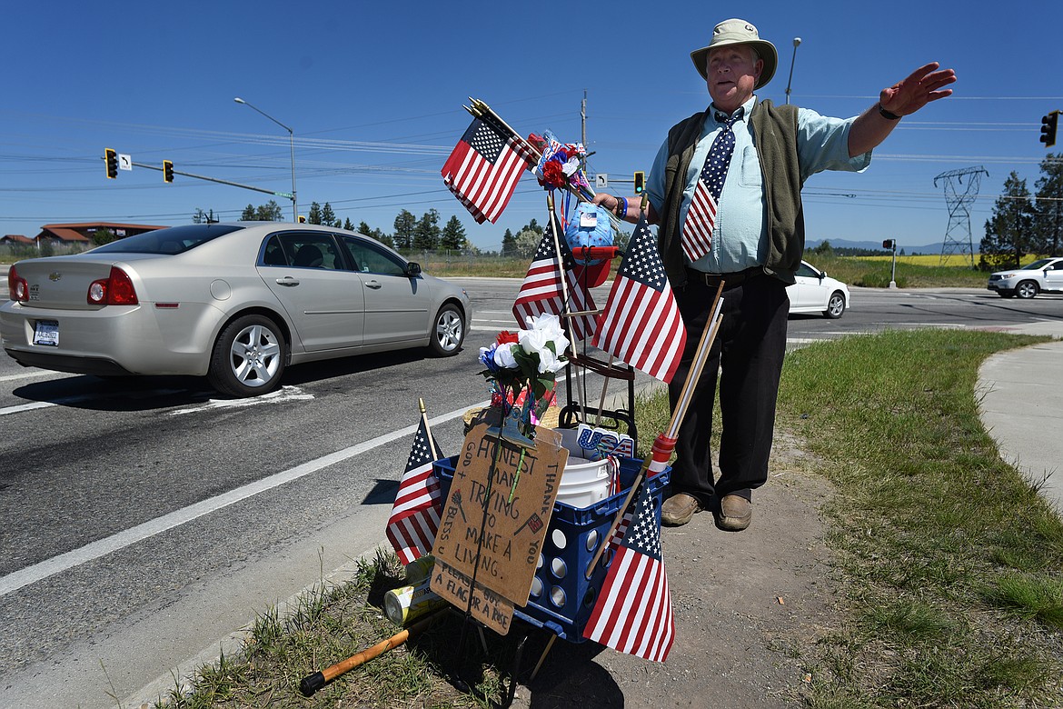 Kalispell's Al Wellenstein endures temperatures over 100 degrees on Wednesday, June 30, 2021, to sell flags, flowers and other wares at the intersection of West Reserve Drive and Hutton Ranch Road. (Jeremy Weber/Daily Inter Lake)