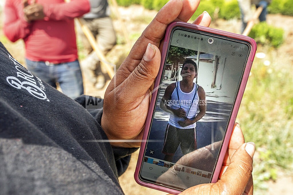 A worker, who declined to be named, looks at a photo of Sebastian Francisco Perez who died last weekend while working in an extreme heat wave, Thursday, July 1, 2021, near St. Paul, Ore. (AP Photo/Nathan Howard)