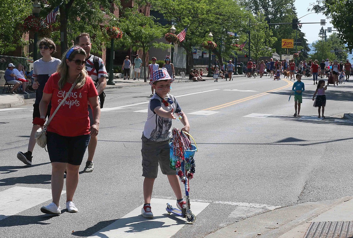 Josiah Goldthorpe, 9, of Coeur d'Alene, tosses candy to spectators Friday during the annual Kiddies Parade on Sherman Avenue.