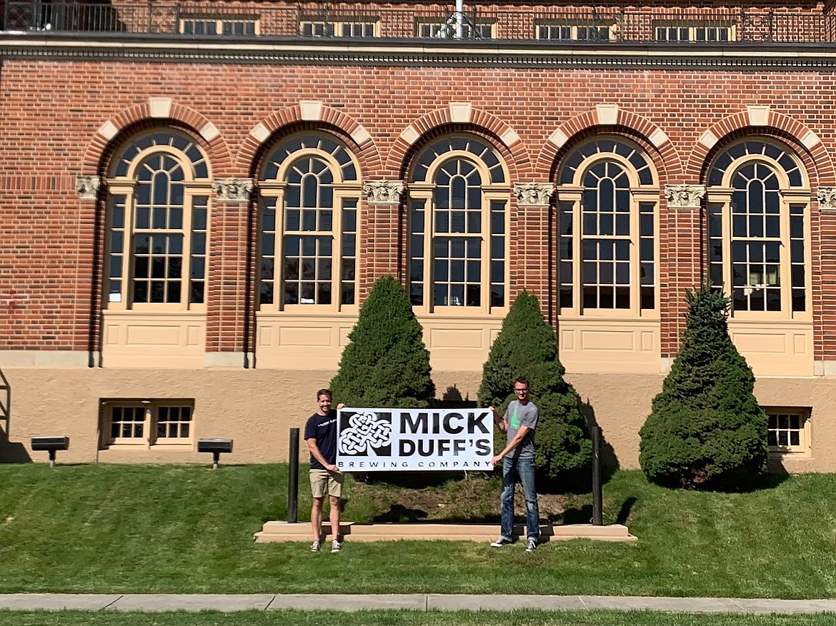 Mickey and Duffy Mahoney hold a MickDuff's Brewing Company banner in front of the old federal building after buying the building in September 2019. The brothers were honored for their 15-month restoration of the building with an Orchid Award for Excellence in Historic Preservation by Preservation Idaho.