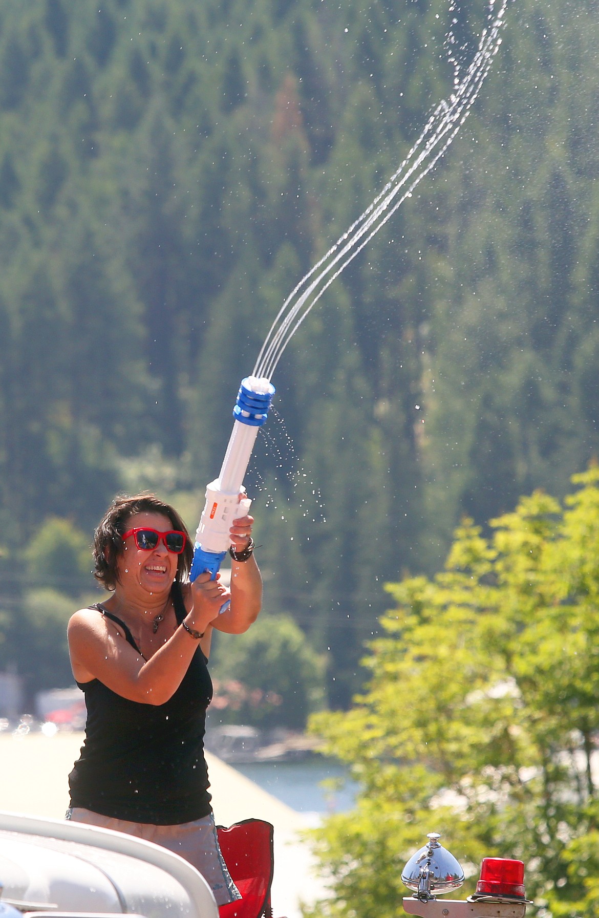 A woman in the Bayview Daze parade sends a stream of water at the crowd.