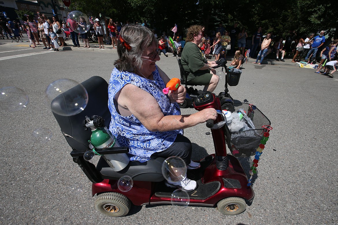 Janice John sends bubbles toward the crowd in Spirit Lake's Fourth of July parade on Sunday.
