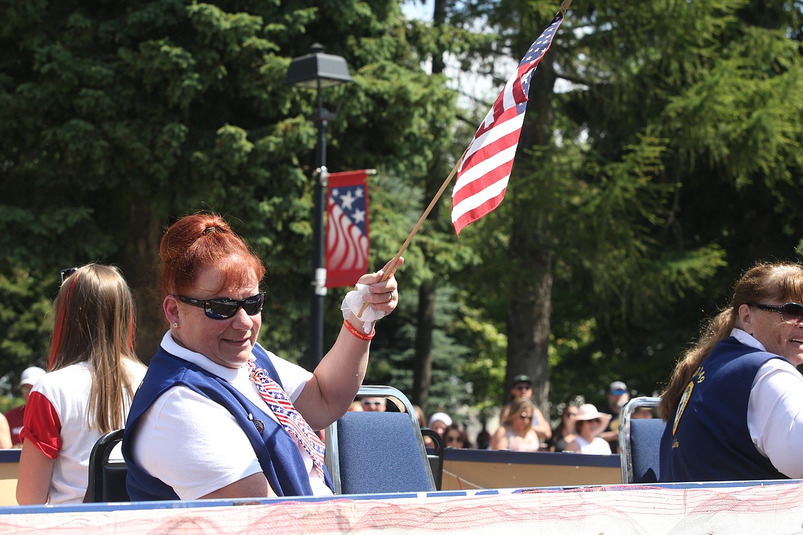 Caren Crumpacker with American Legion Auxiliary 149 in Athol waves a flag on Sunday.