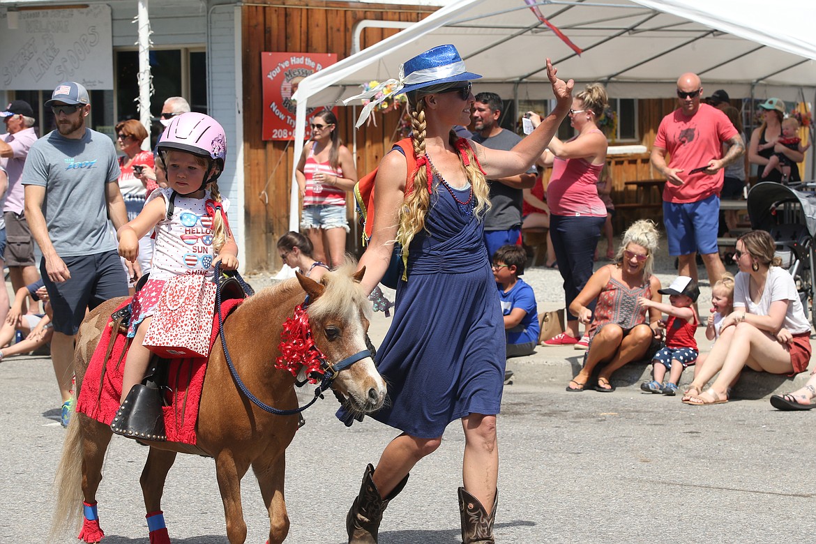 Ashtyn Hahaj holds the reins of her equine friend “Scooter McGee” as he was led by Ashtyn’s mom, Jess Hahaj in Spirit Lake's Fourth of July parade Sunday.