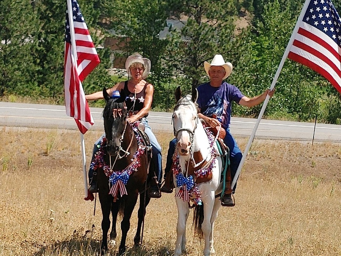 Nancy Gabel and Larry Carnahan got out on horseback by the Kingston overpass to celebrate the 4th of July with those traveling by.